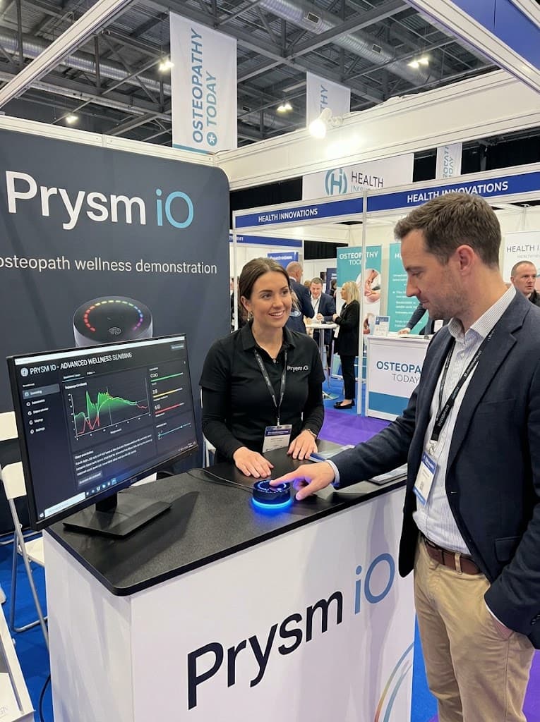 A Prysm iO scan being demonstrated to a visitor at an osteopathy exhibition stand