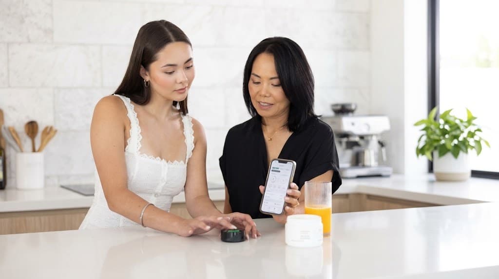 Two people reviewing a Prysm iO wellness score together on the connected app